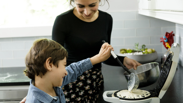 putting batter on waffle iron