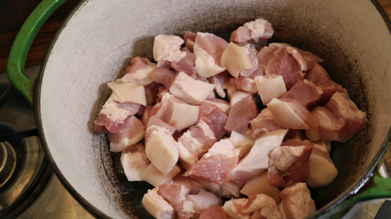 Dutch oven full of raw pork belly pieces