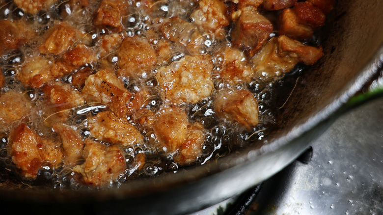 Pork cracklins frying in pot