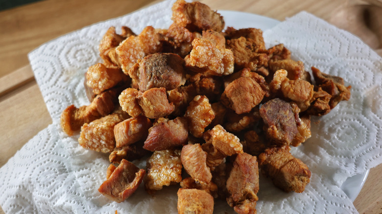 Pile of pork cracklins on plate lined with paper towels