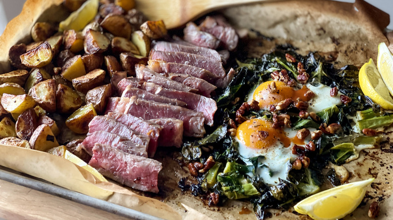 Sheetpan brunch with potatoes, steak, collards, and eggs