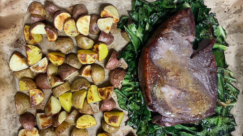 Potatoes, collard greens, and steak on sheet pan