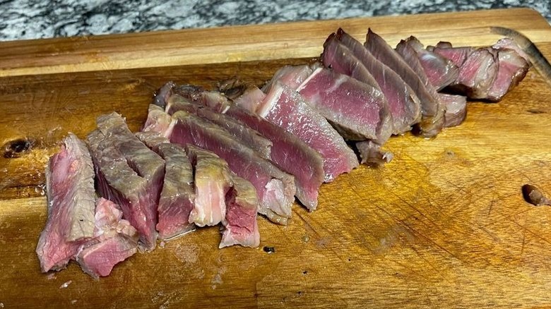 Sliced steak on cutting board