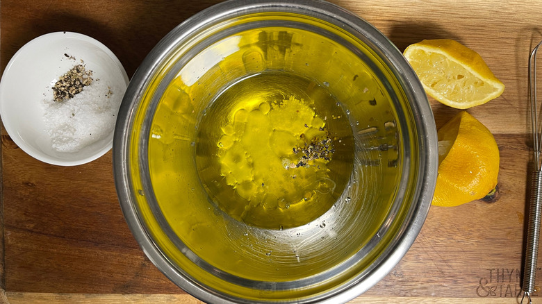 Salt and pepper on plate, oily dressing in bowl, lemon wedges