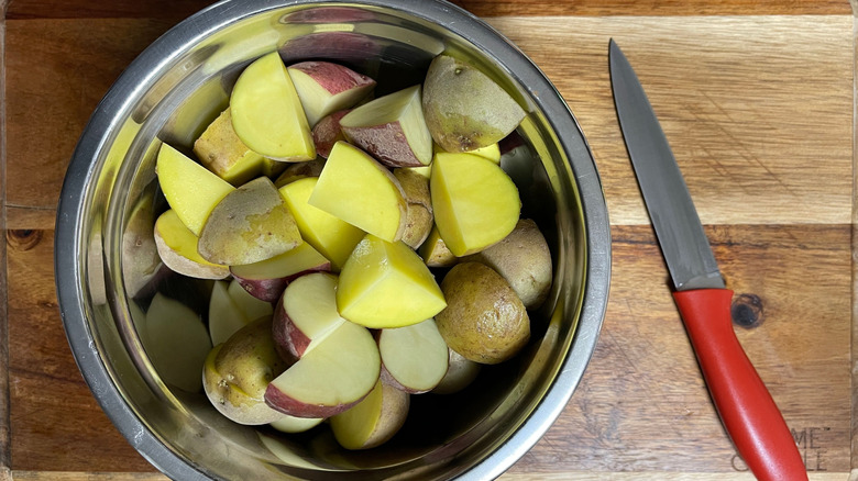 Chopped potatoes in bowl next to knife