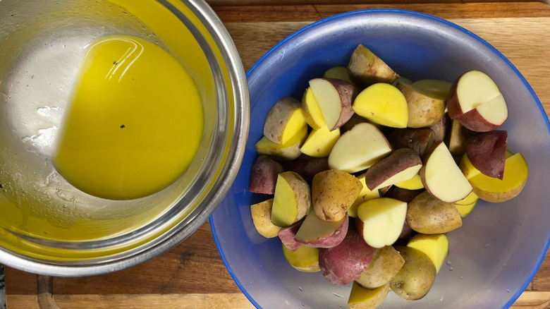 Dressing pouring into bowl of potatoes