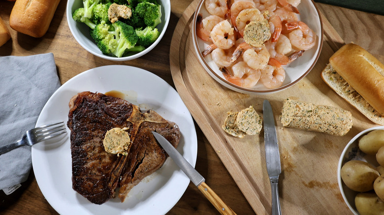 Spread of steak, broccoli, shrimp, and bread with cowboy butter on them