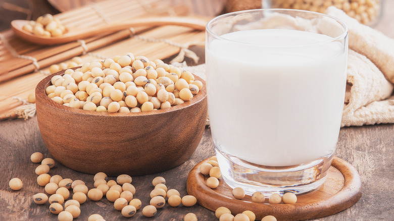 Soy milk in glass next to soybeans