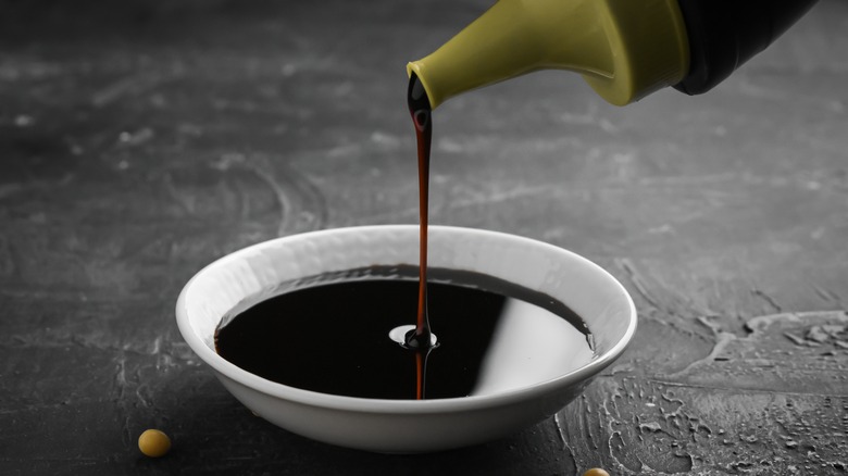 pouring soy sauce into dish