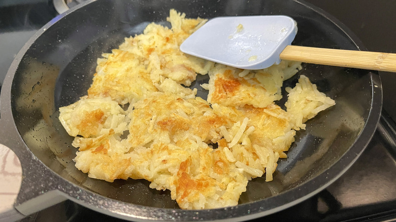 browned hash browns cooking in skillet