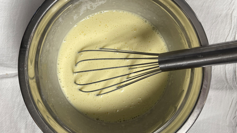 whisking eggs and cream in bowl