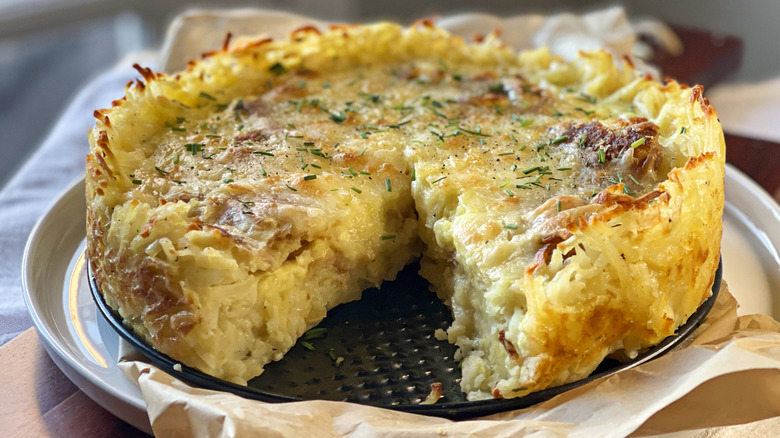 Spanish tortilla-inspired quiche with hash brown crust with slice cut out