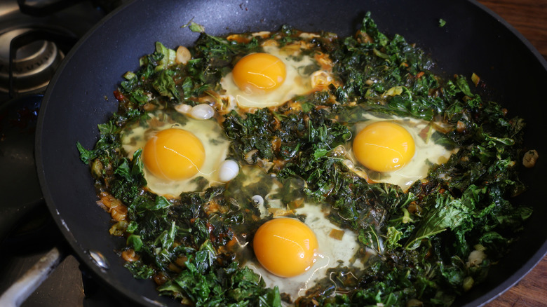 eggs in skillet with kale