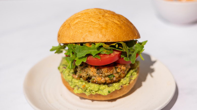 salmon guacamole burger on plate 