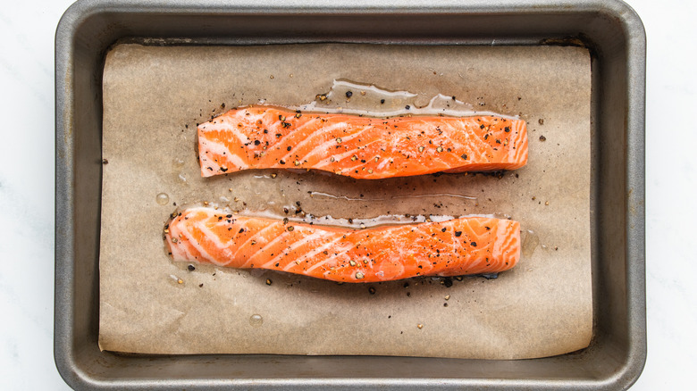 Two salmon fillets on baking sheet