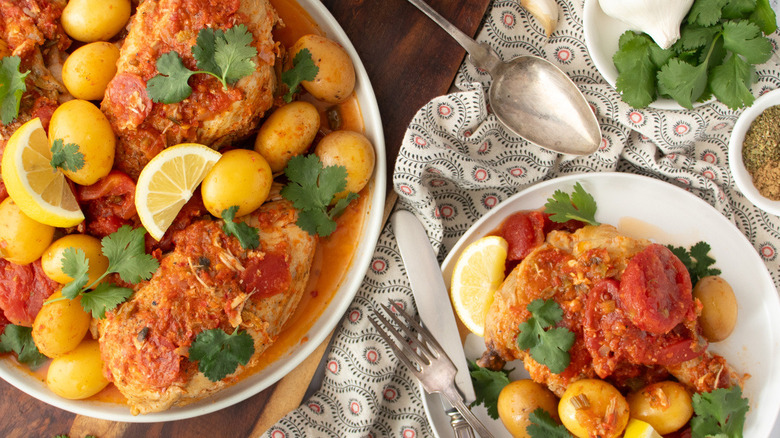 chicken with tomatoepiri piri chicken with tomatoes, lemons, and potatoes on platess and potatoes