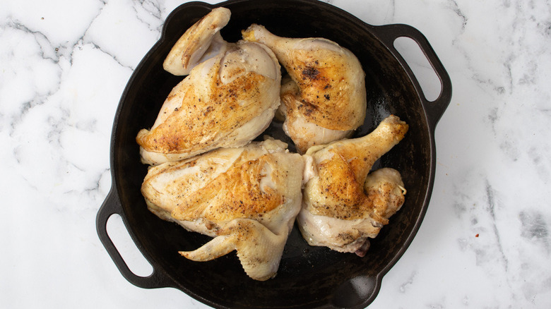 chicken searing in cast iron pan