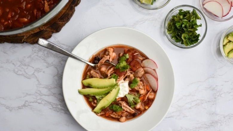 Spicy chicken soup with sliced avocado