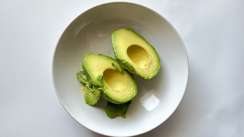 halved avocado in bowl