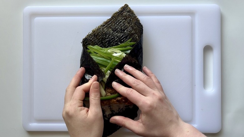 hands rolling up sushi burrito