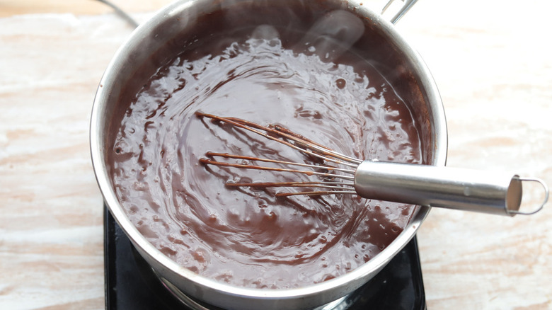 chocolate pudding in pot with whisk