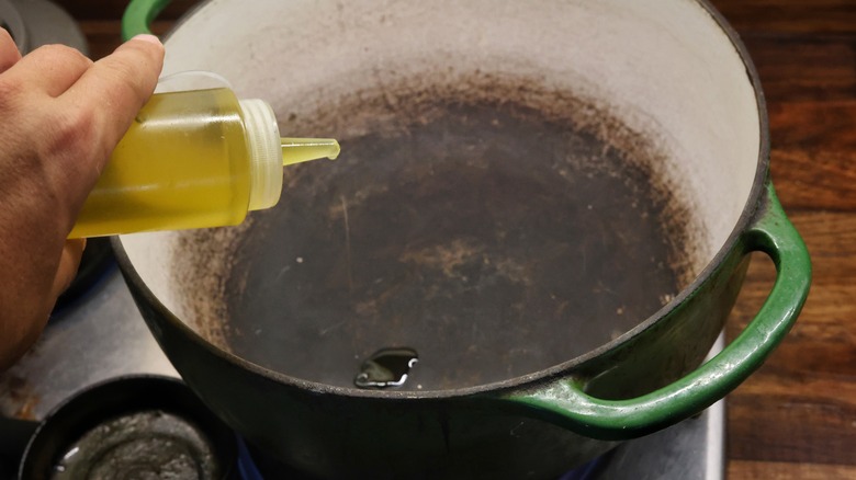 adding oil to pot