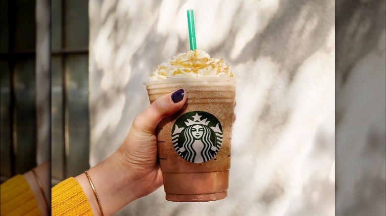 Woman holding Starbucks Caramel Frappuccino