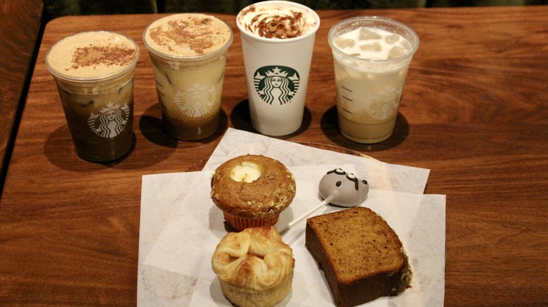 Group of Starbucks drinks and pastries on wooden table