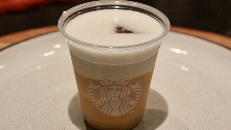 Sample cup of Iced Apple Crisp Chai with cold foam