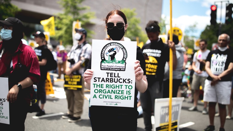 Girl holding white picket sign 