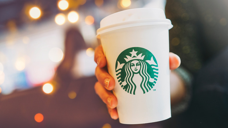 A person holding a cup from Starbucks