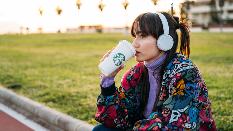 Girl drinking from Starbucks cup 