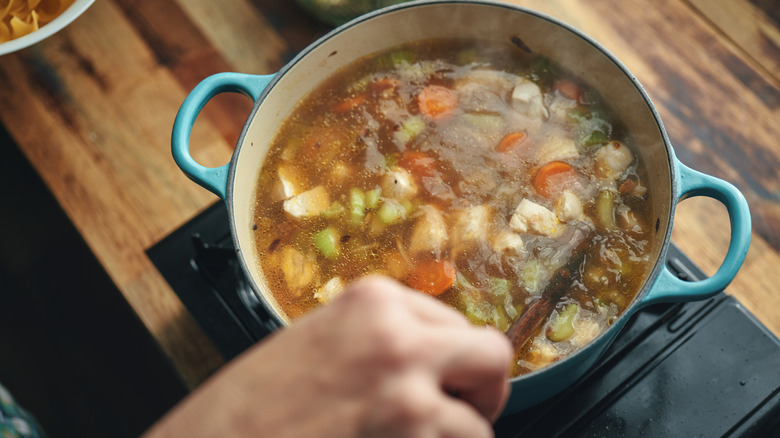 stirring soup in pot on stovetop