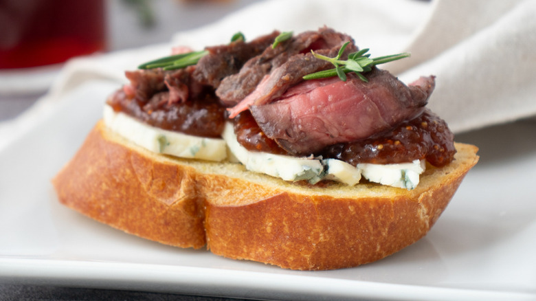 steak blue cheese crostini on white plate