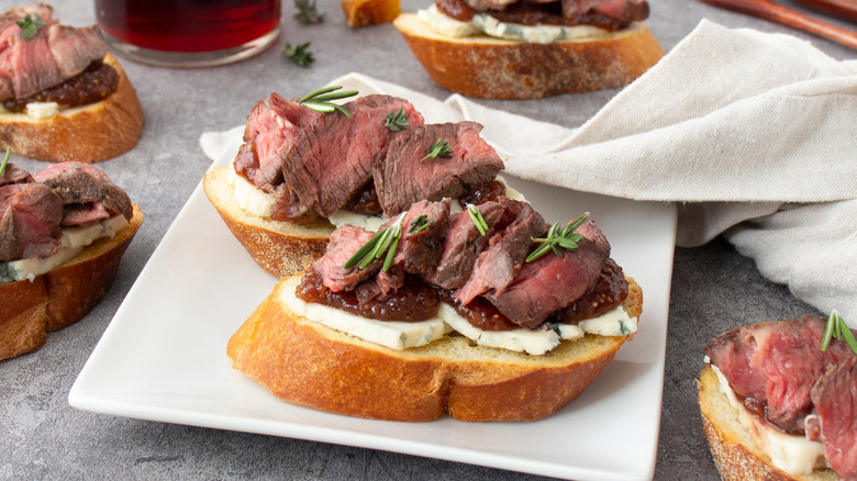 steak blue cheese crostini on white plate