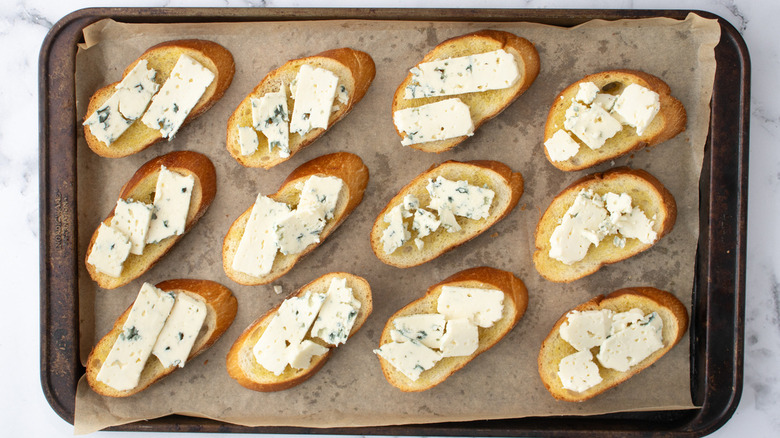 crostini with cheese on baking sheet