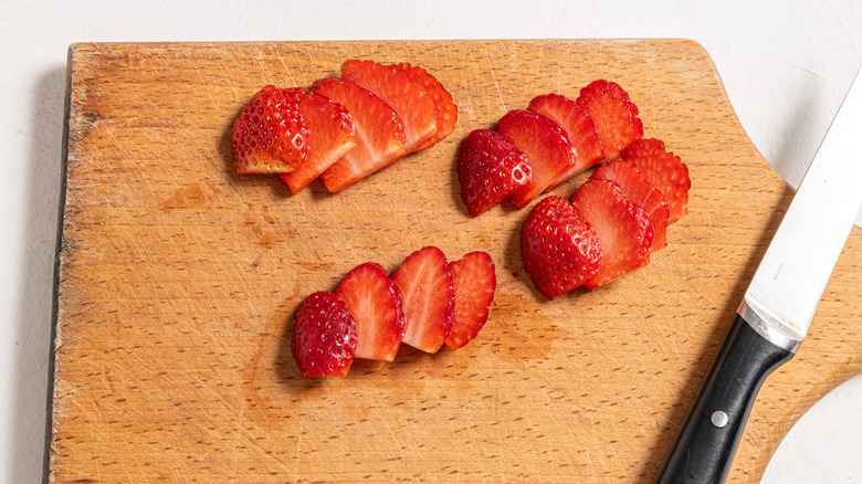 sliced strawberries on cutting board