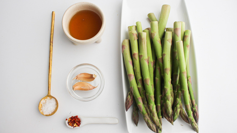 adding pepper flakes to asparagus