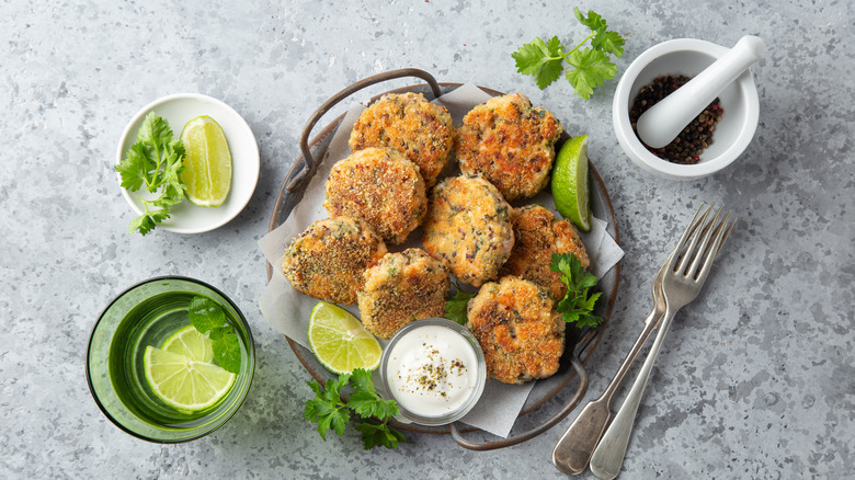 Platter of salmon fritters with lime garnishes