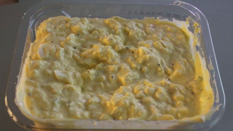 Close up of egg salad in a clear plastic container