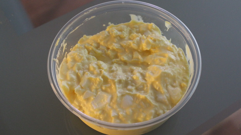 Circular plastic container filled with egg salad