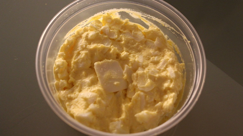 Closeup of egg salad in a clear circular container