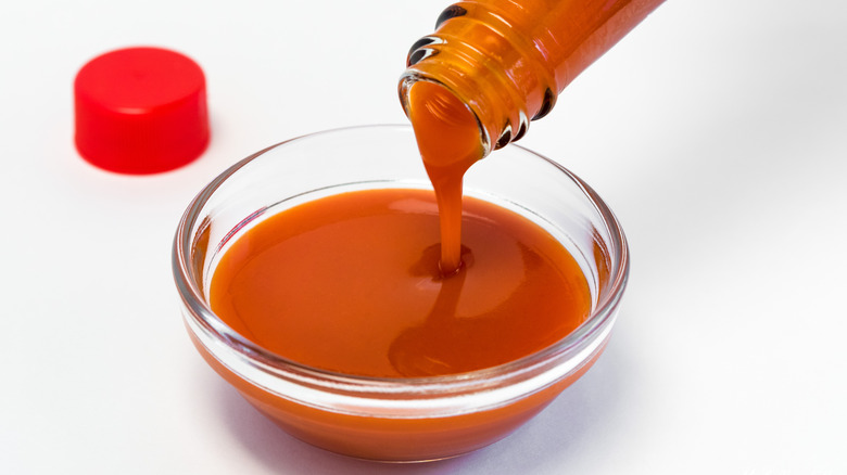 Hot sauce pouring into bowl