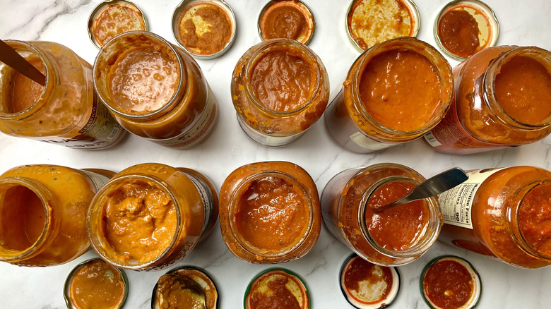 Open jars of vodka sauces with spoons for tasting