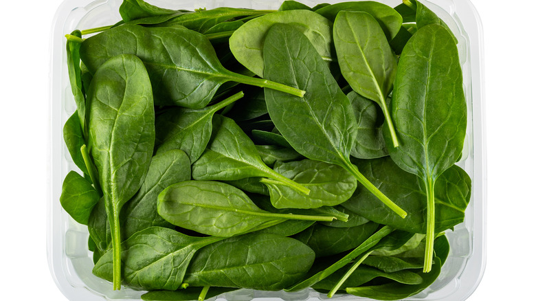 Top down view of a spinach in a clear plastic container