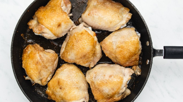 seared chicken thighs in skillet