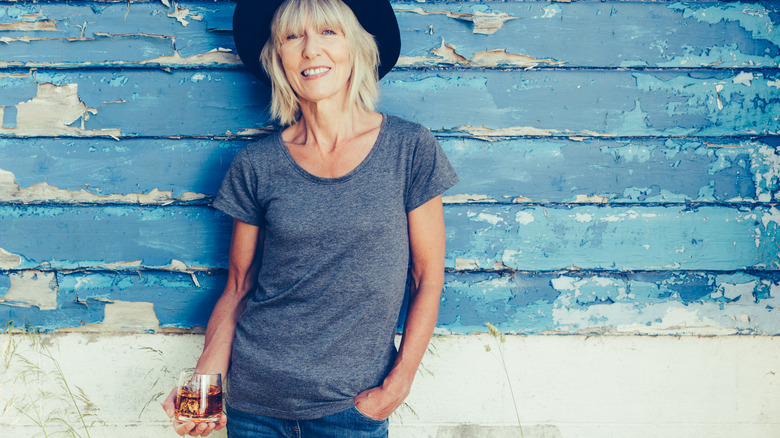 woman outside with a glass of bourbon