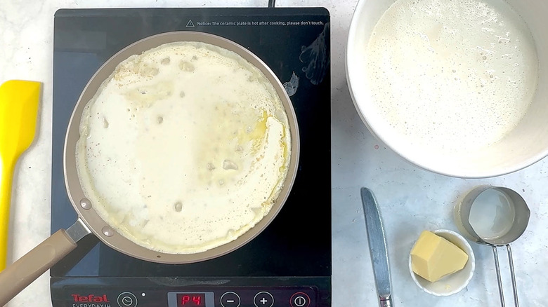 adding batter to crepe pan