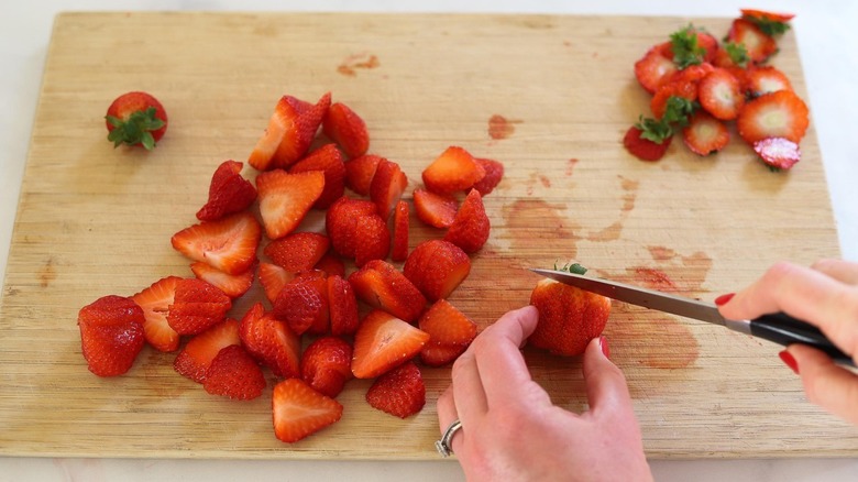 chopping strawberries on cutting board