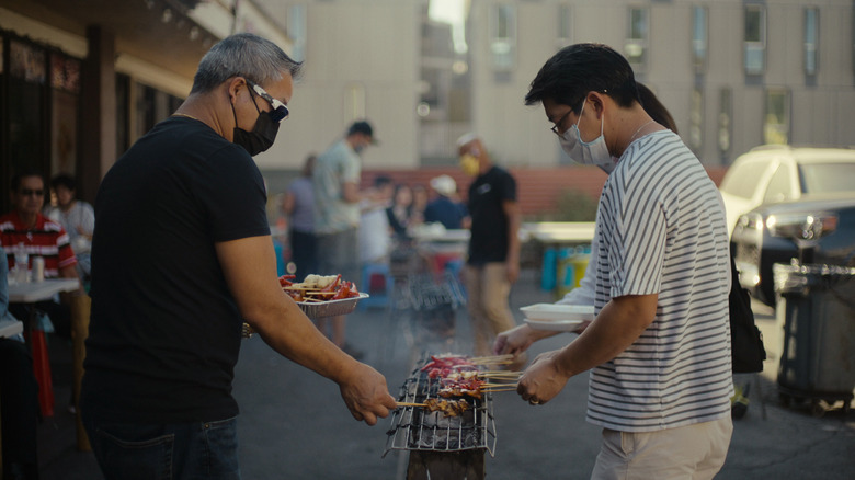 People roasting meat on a a grill